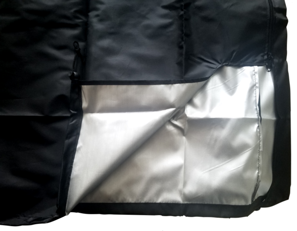 A black and silver blanket with a white sheet.
