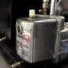 A close up of the side of an old fashioned water heater.