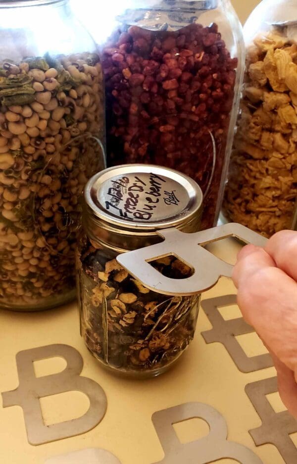 A person is holding a spoon in front of jars.