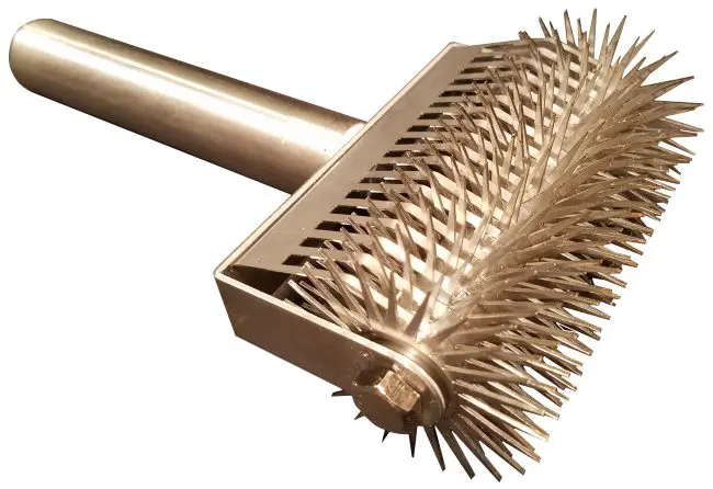 A gold colored brush with long, spiky hair.