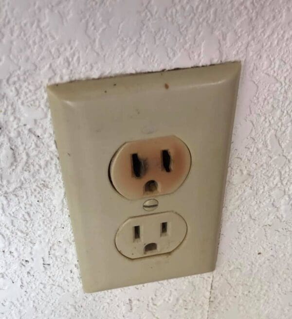 A white wall outlet with two holes in it.