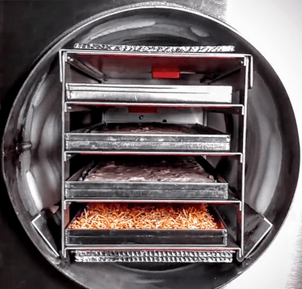 A close up of an oven with trays of food in it