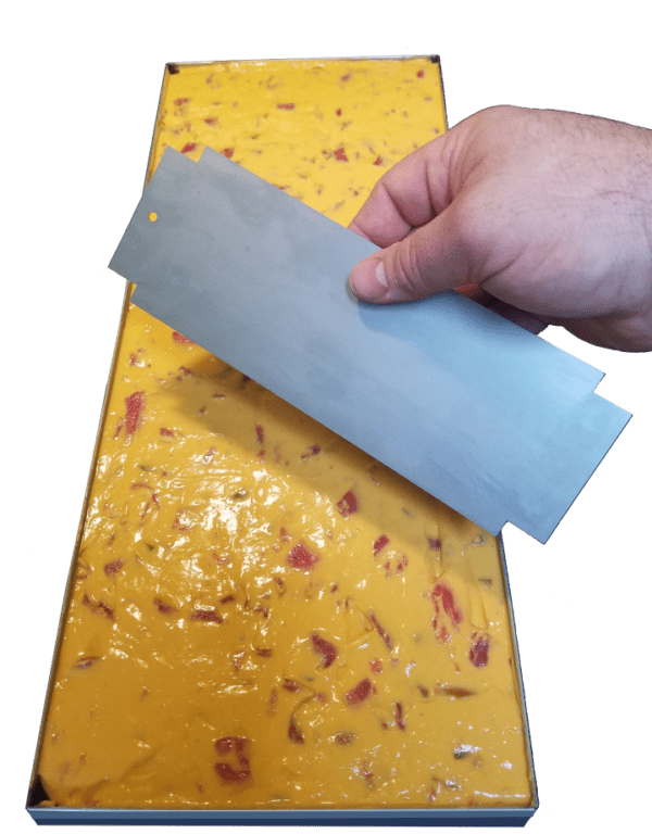 A hand holding a piece of paper over a yellow object.